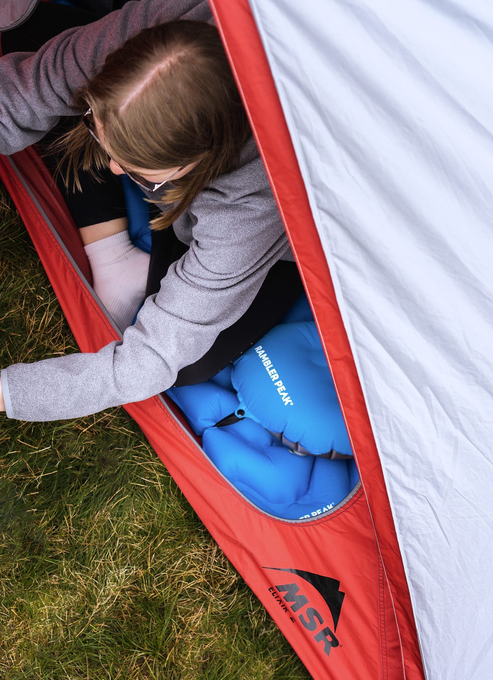 A camper reaching into a tent pitched on Peak District moorland