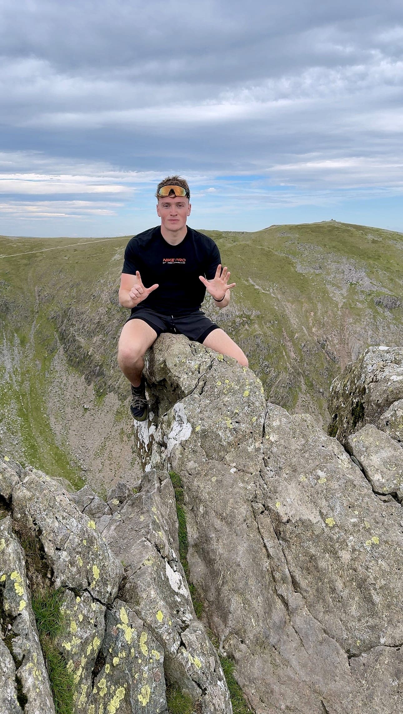 George, founder of Rambler Peak, sat on the summit rocks of Dow Crag holding up seven fingers for his seventh Wainwright of the day